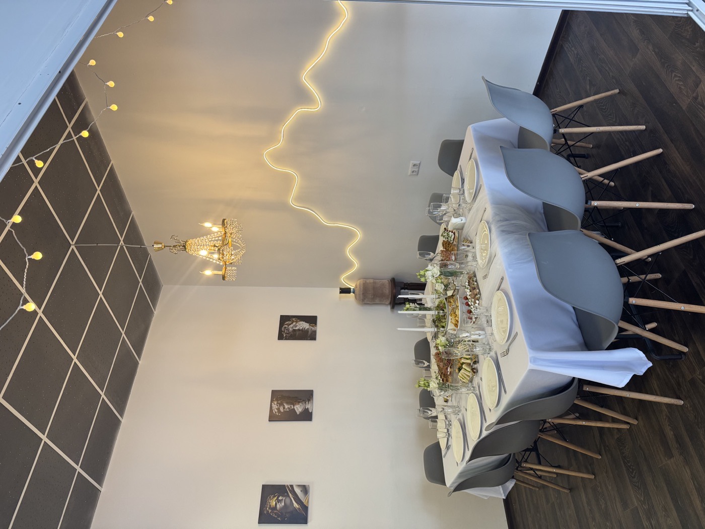 Стол с зелёными цветами, свечами и бокалами на фоне неоновой подсветки