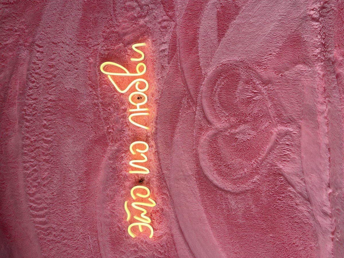 Неоновая вывеска «это по любви» на розовой стене